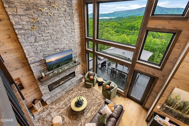 4408 Stackstone Rd, Sevierville, TN 37862 - living area with a stone fireplace, light wood-type flooring, and wood walls