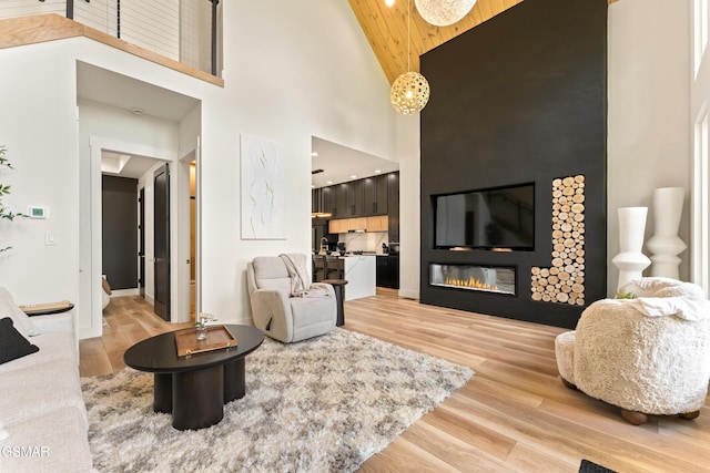 1163 Reedmont Way, Sevierville, TN 37876 - living area with high vaulted ceiling, light wood finished floors, wooden ceiling, recessed lighting, and a glass covered fireplace