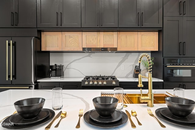 1163 Reedmont Way, Sevierville, TN 37876 - kitchen with freestanding refrigerator, black oven, extractor fan, backsplash, and light stone countertops