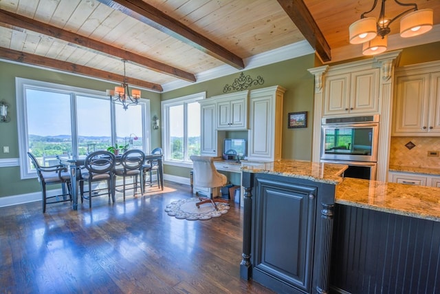 kitchen featuring light stone countertops, backsplash, stainless steel double oven, decorative light fixtures, and a chandelier