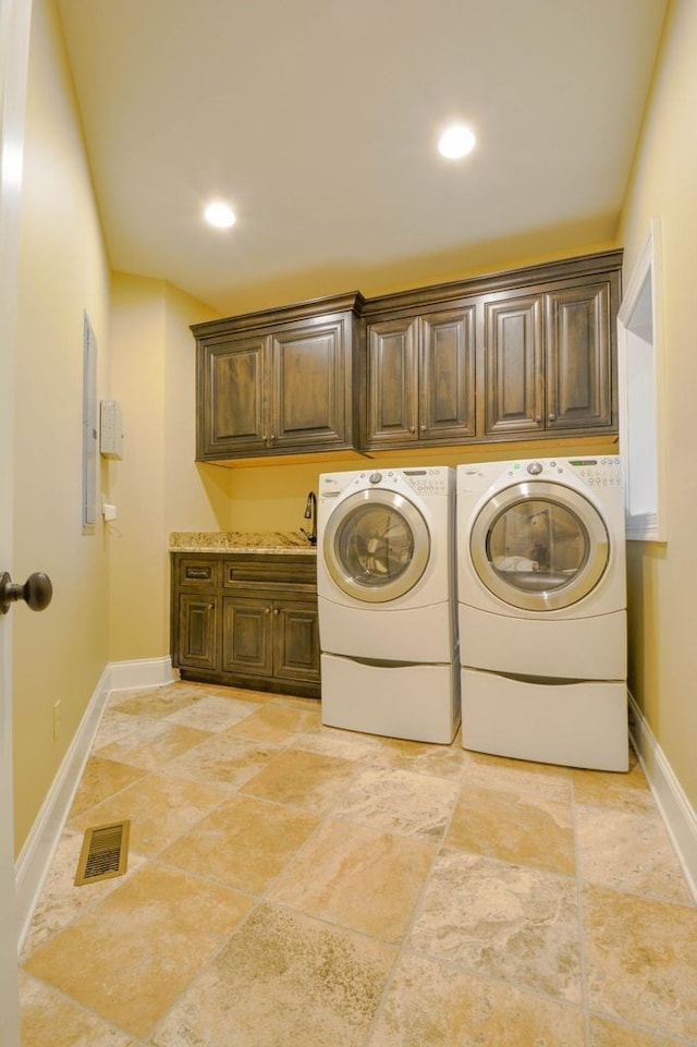 washroom with washer and clothes dryer and cabinets