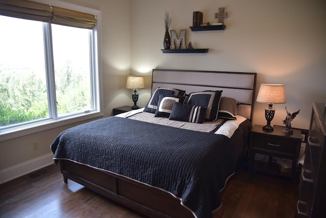 bedroom with dark hardwood / wood-style floors