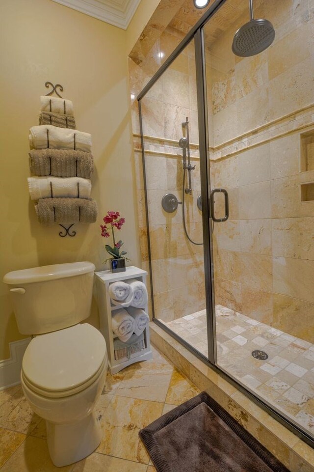 bathroom featuring toilet, ornamental molding, and walk in shower