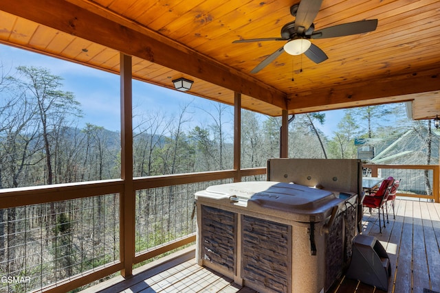 deck featuring a ceiling fan and a view of trees