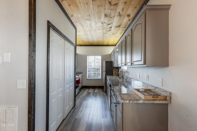 kitchen featuring visible vents, high end stainless steel range oven, dark wood-type flooring, wood ceiling, and a sink