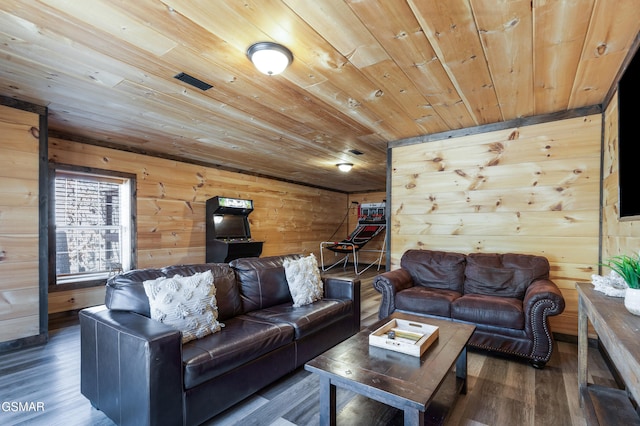 living area with wooden ceiling, wooden walls, visible vents, and wood finished floors