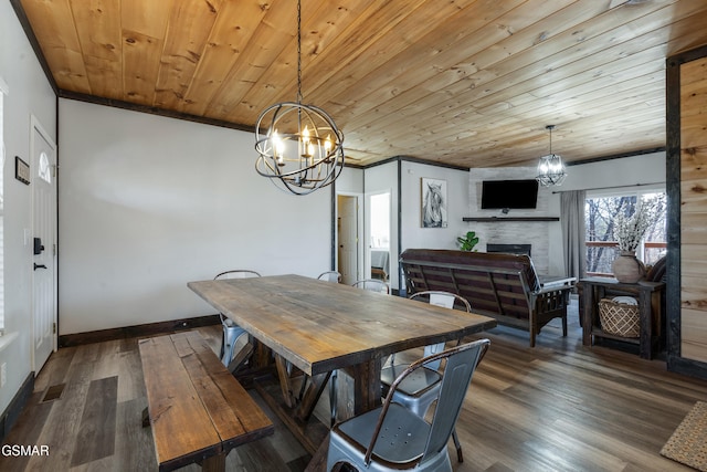 dining space with crown molding, a fireplace, wood finished floors, a chandelier, and wooden ceiling