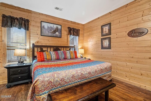 bedroom featuring wood-type flooring and wooden walls