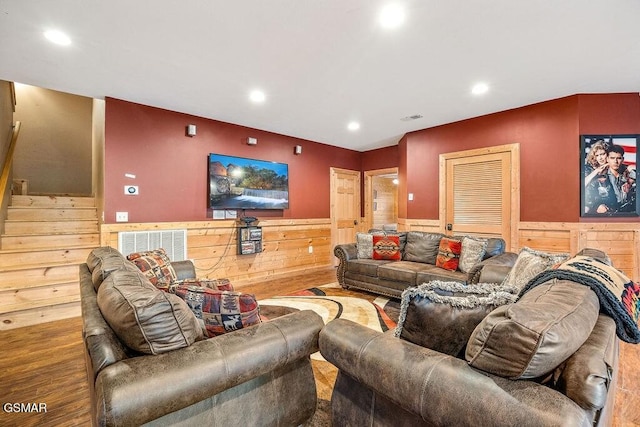 living room with hardwood / wood-style flooring and wood walls