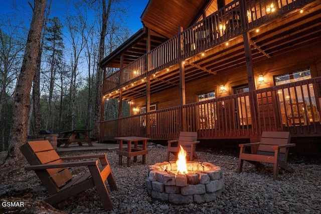 view of property exterior with a wooden deck and an outdoor fire pit