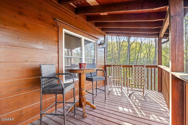 sunroom with beam ceiling, wood ceiling, and a healthy amount of sunlight