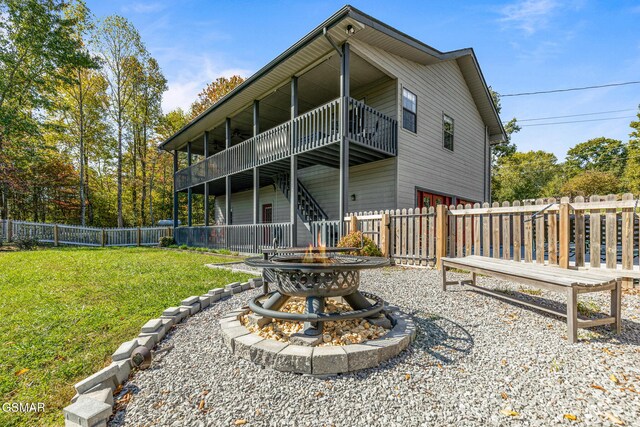 3225 Laurelwood Ave, Sevierville, TN 37862 - back of property featuring a deck, a fire pit, a fenced backyard, a yard, and stairs