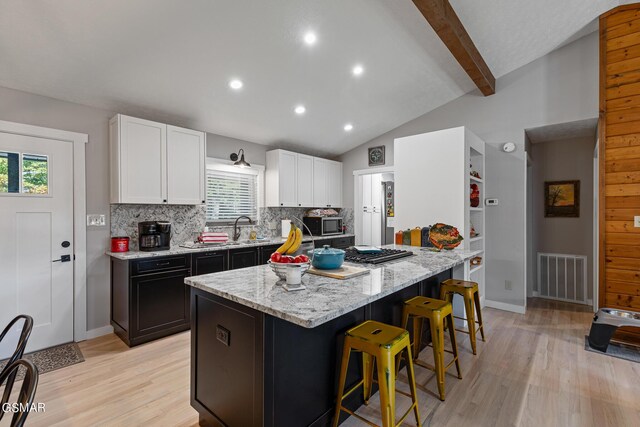 3225 Laurelwood Ave, Sevierville, TN 37862 - kitchen featuring light wood finished floors, backsplash, visible vents, a sink, and stainless steel microwave