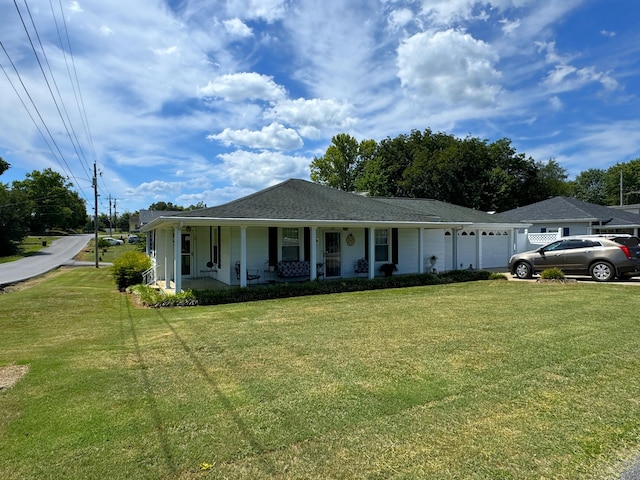 ranch-style house featuring covered porch, a garage, and a front yard