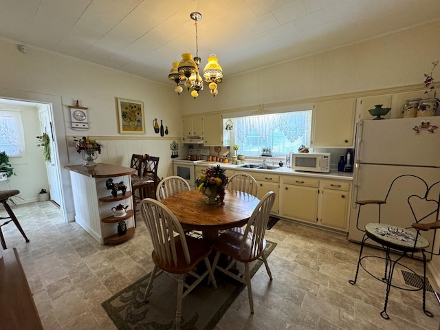 dining area featuring sink and a notable chandelier