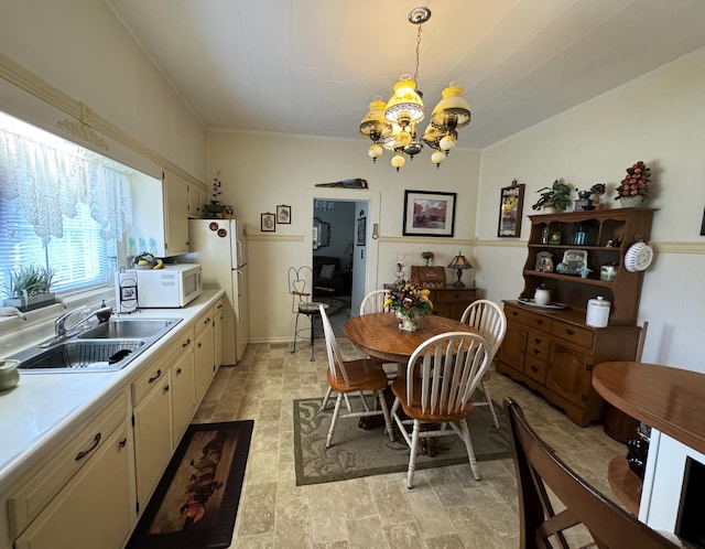 dining area featuring a notable chandelier and sink