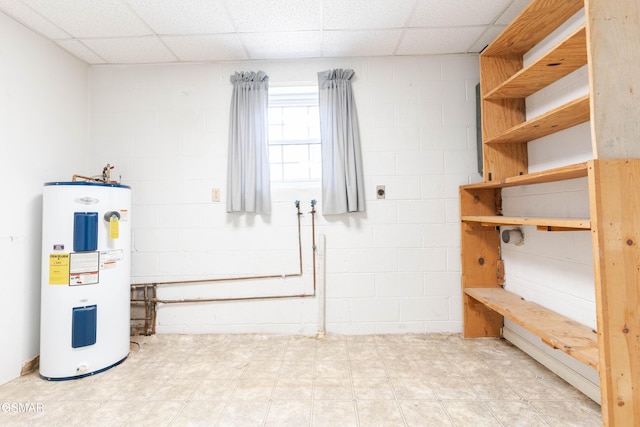 interior space with a paneled ceiling and water heater
