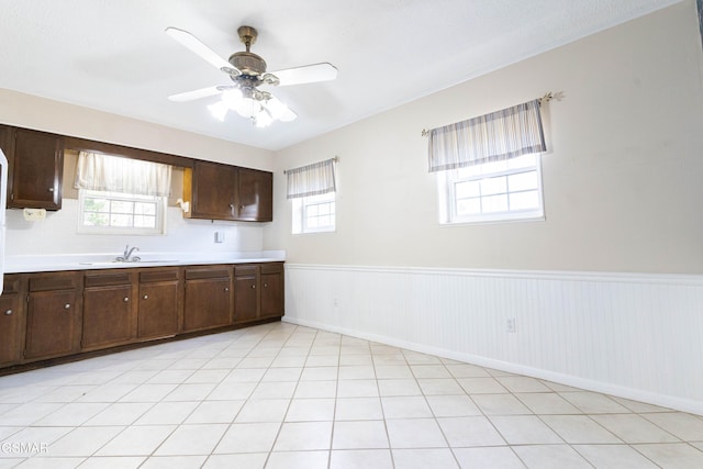kitchen featuring ceiling fan, dark brown cabinets, and sink