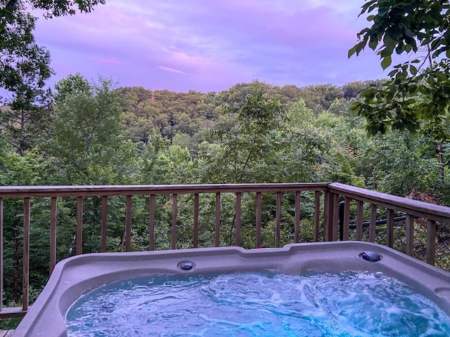 deck at dusk with a hot tub