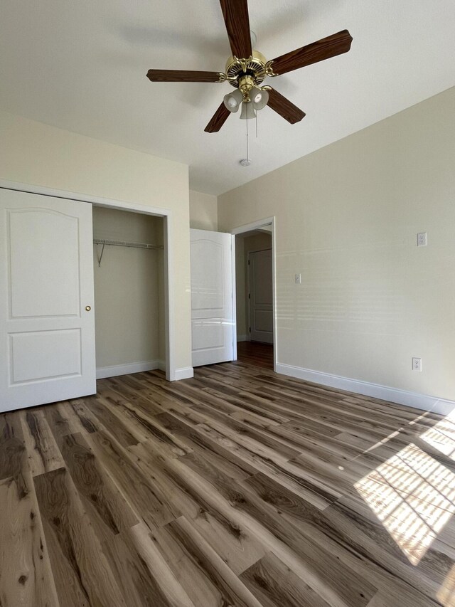 unfurnished bedroom featuring ceiling fan, a closet, and dark hardwood / wood-style floors