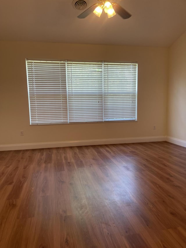 spare room featuring ceiling fan and dark wood-type flooring