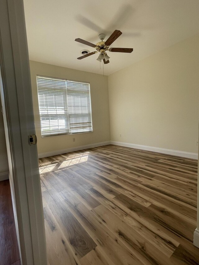 empty room featuring wood-type flooring and ceiling fan