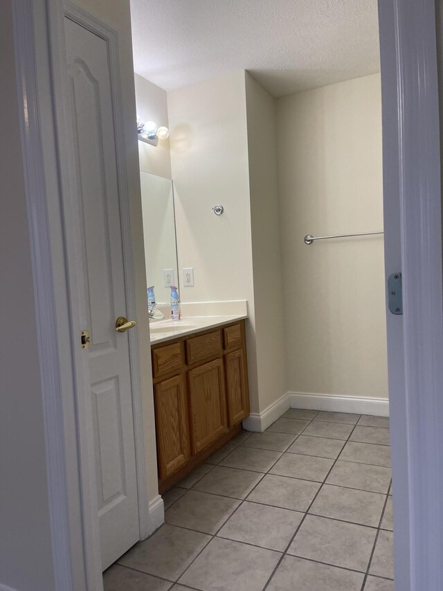 bathroom with tile patterned floors, vanity, and a textured ceiling