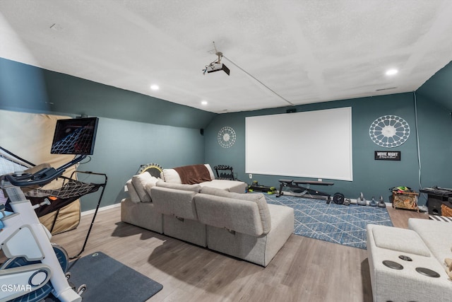 cinema room with recessed lighting, wood finished floors, and lofted ceiling