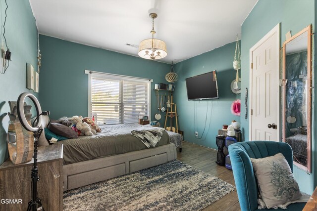 bedroom featuring visible vents and wood finished floors