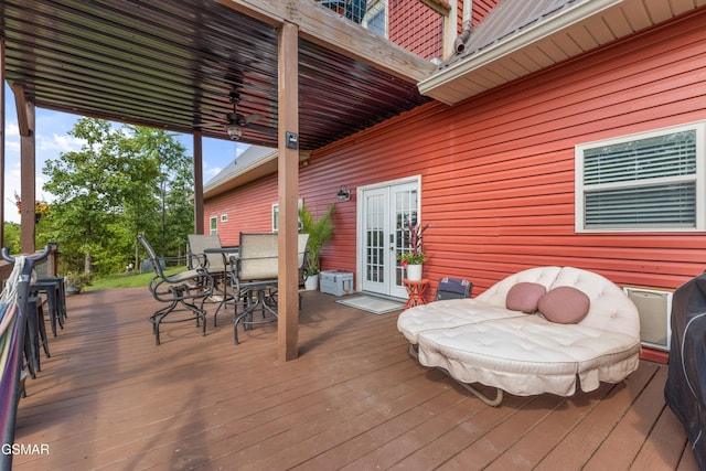 wooden terrace with outdoor dining space and french doors