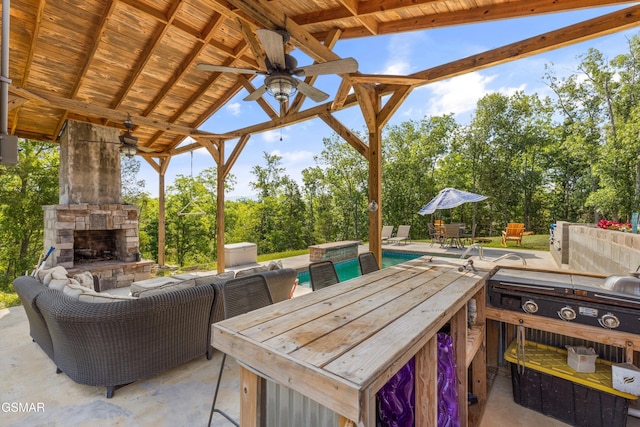 view of patio featuring an outdoor pool, outdoor dining space, ceiling fan, and an outdoor stone fireplace