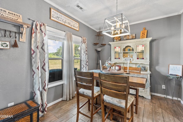 dining area with a notable chandelier, baseboards, light wood-type flooring, ornamental molding, and visible vents