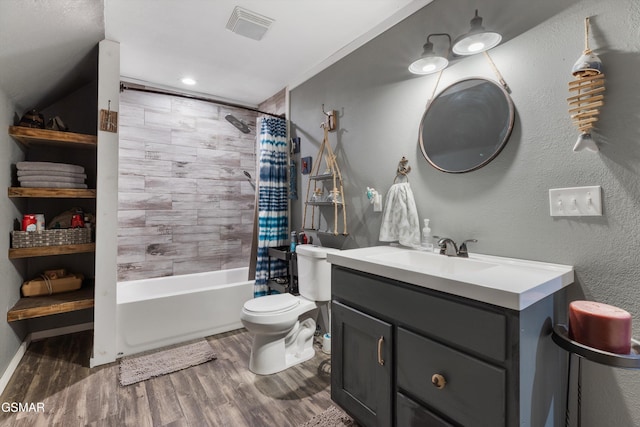 bathroom with vanity, visible vents, toilet, wood finished floors, and shower / tub combo with curtain