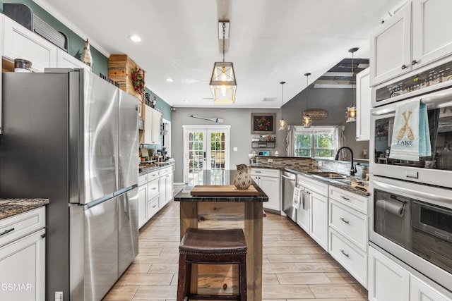 kitchen featuring a sink, appliances with stainless steel finishes, a peninsula, recessed lighting, and french doors