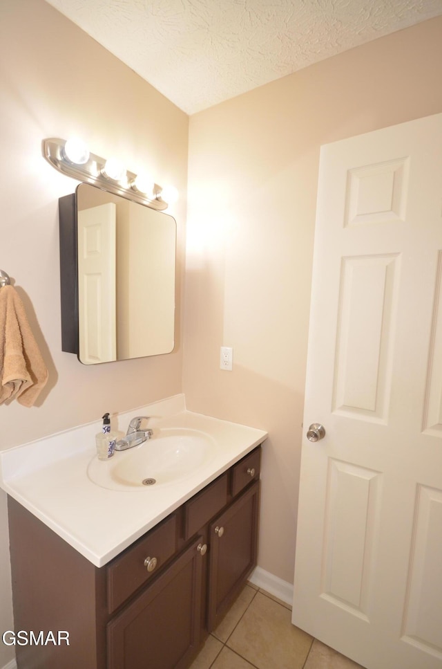 bathroom with tile patterned floors, a textured ceiling, and vanity