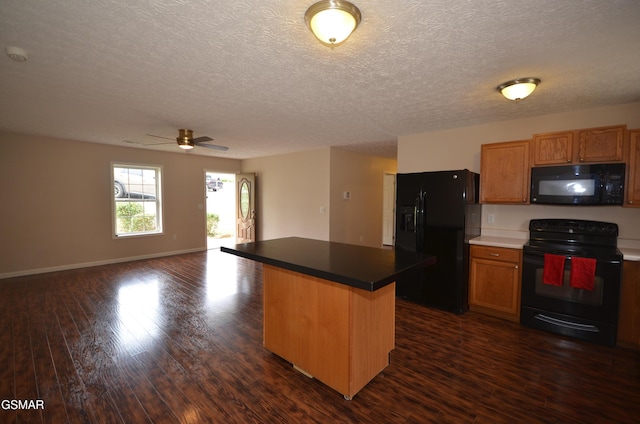 kitchen with black appliances, a ceiling fan, a kitchen island, open floor plan, and dark wood finished floors