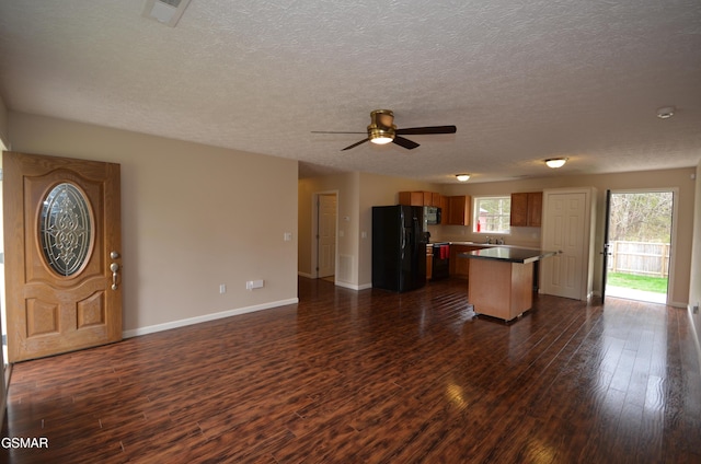 interior space featuring dark wood-type flooring, black appliances, and open floor plan