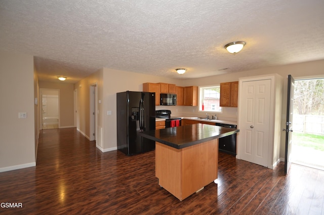 kitchen featuring a kitchen island, dark wood-type flooring, baseboards, black appliances, and a sink