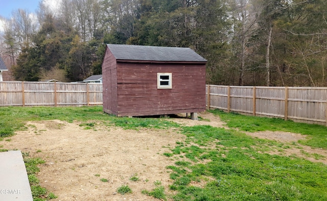 view of yard with a storage unit, an outbuilding, and a fenced backyard