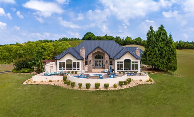 rear view of property with a chimney, a storage shed, an outdoor pool, a patio area, and stone siding