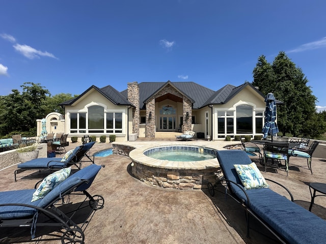 outdoor pool with a patio and an in ground hot tub