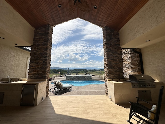 view of pool with area for grilling, a patio, a pool with connected hot tub, and a sink