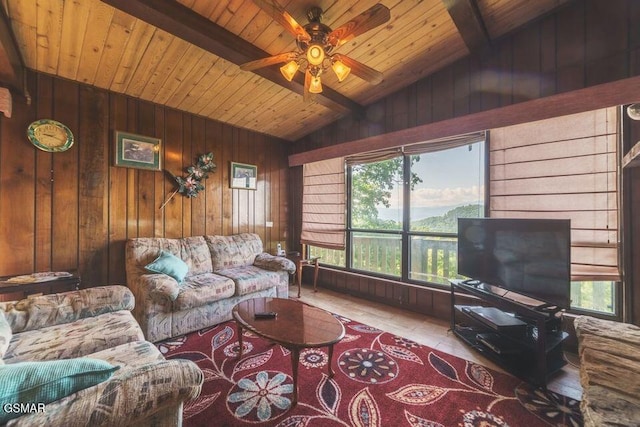 living area featuring ceiling fan, wooden walls, wooden ceiling, and vaulted ceiling with beams