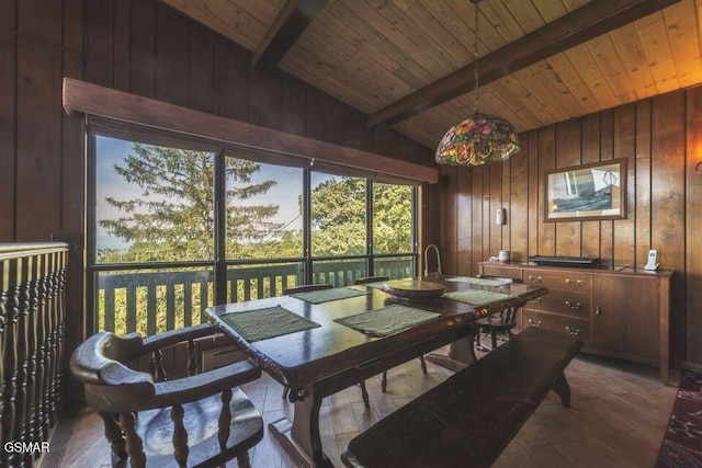 dining room with wood walls, wood ceiling, lofted ceiling with beams, and wood finished floors