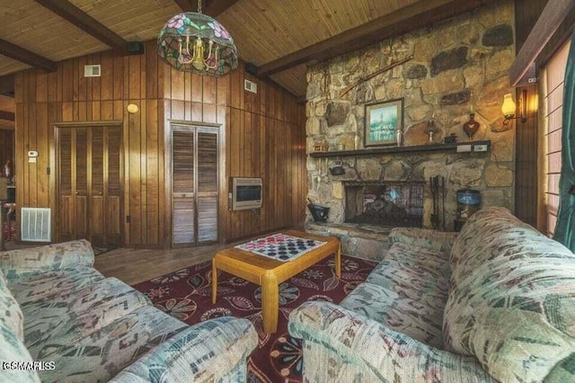 living room featuring beam ceiling, heating unit, visible vents, and wood walls