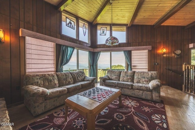 living room with beam ceiling, wooden walls, plenty of natural light, and wooden ceiling