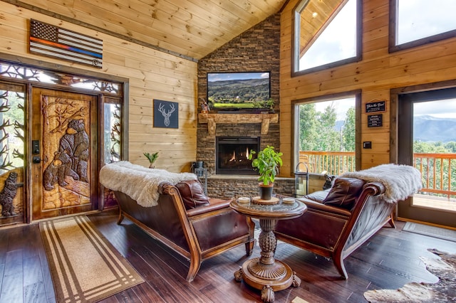 living area featuring wood-type flooring, a fireplace, wood ceiling, and wooden walls