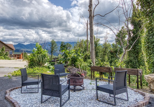 view of patio / terrace with a fire pit and a mountain view