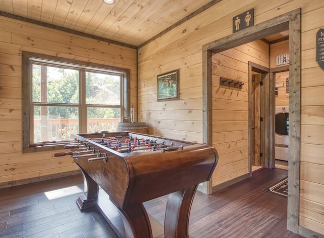 rec room featuring dark wood finished floors, wood walls, washer / dryer, wooden ceiling, and baseboards