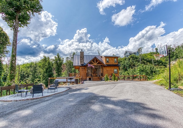 view of front of property featuring a chimney and metal roof